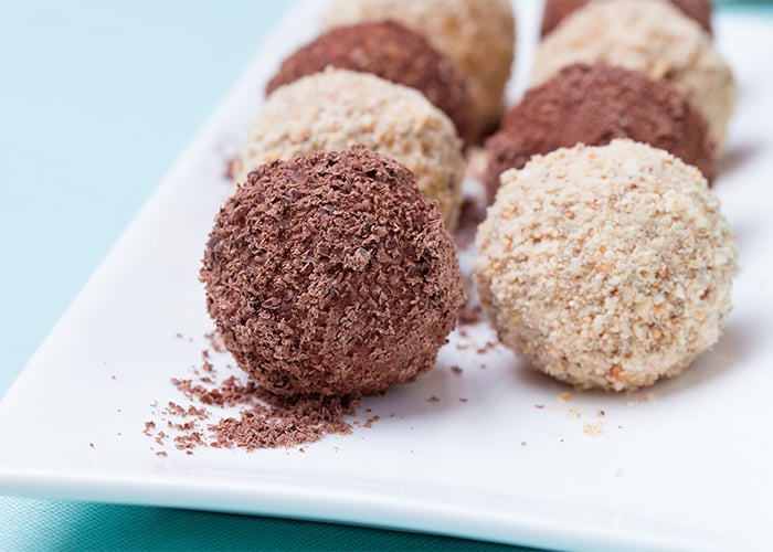 keto-donut-holes-with-chocolate-and-almonds-powder-on-white-plate