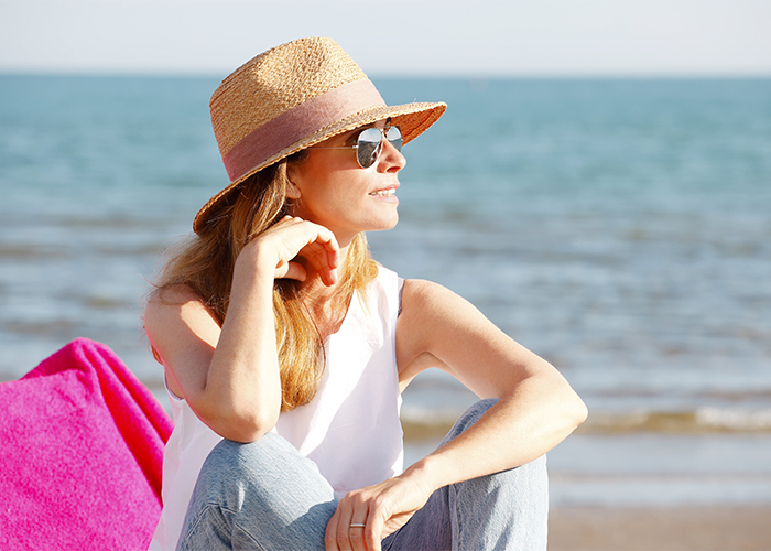 woman-enjoying-sunshine-while-relaxing-on-the-beach