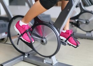 Woman doing cardio exercises on gym exercise bike
