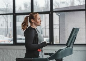 Slightly curvy woman doing cardio training on treadmill