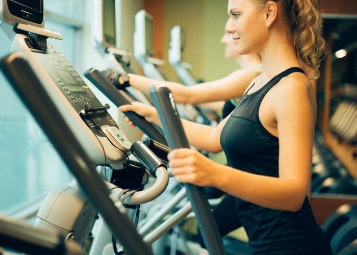 Woman at the gym using elliptical machine for cardio training