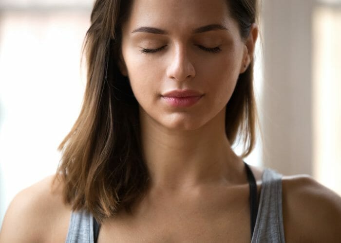 Woman with eyes closed practicing breathing techniques