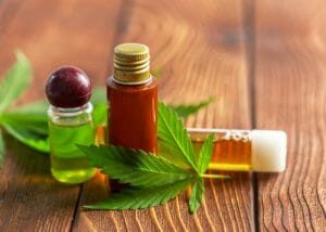 cbd cannabis oil in different small bottles on a wooden table