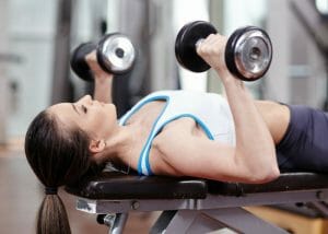 woman doing chest exercises with dumbbells