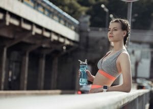 woman in fitness clothes holding a water bottle