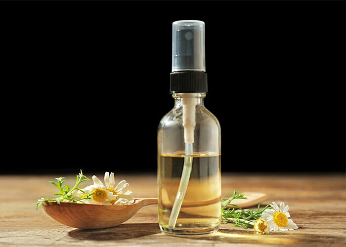 A bottle of homemade essential oil room mist with coconut oil, rosemary essential oil, and bergamot essential oil
