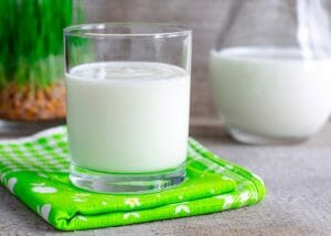 A glass of homemade yogurt on a green tablecloth