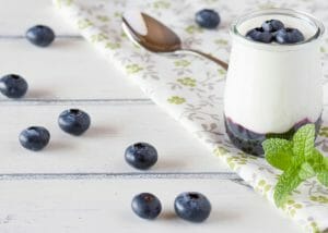 A glass of homemade yogurt with blueberries and blueberry puree