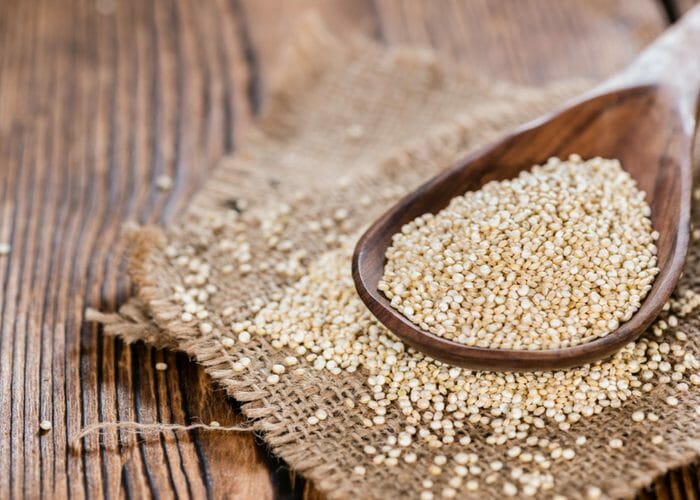 wooden spoon filled with gluten free quinoa grains