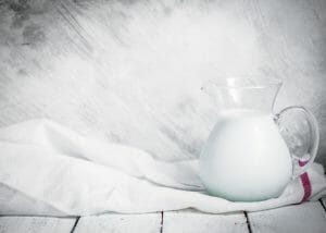A pitcher of milk on a white tablecloth
