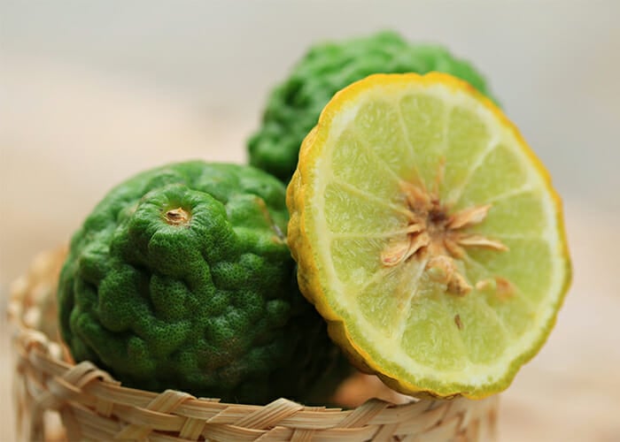 Yellow and green kaffir limes in a woven basket 