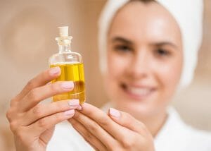 Woman in a spa holding a bottle of lemon essential oil