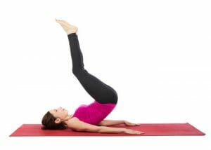 woman lying on exercise mat doing reverse crunch lower ab exercises