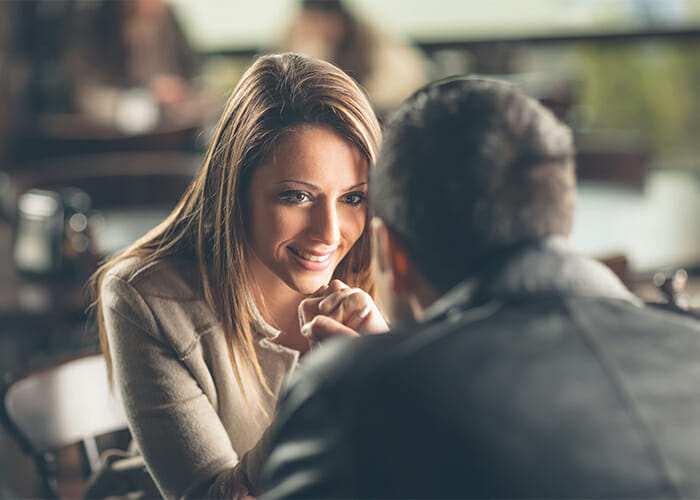 Woman sitting across from her date smiling in a restaurant