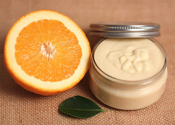 A jar of homemade orange essential oil dark spot lightening lotion