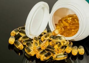 yellow vitamin d capsules pouring out of a bottle