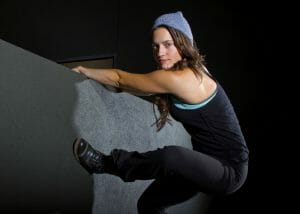 female parkour artist climbing a wall at night