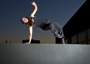 woman doing parkour jumping over a wall