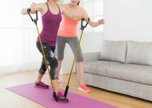 a woman doing resistance band training at home with her trainer