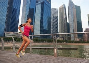 Woman running for weight loss outdoors with a city landscape