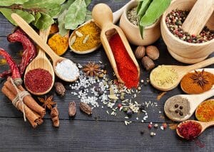 A variety of spices, herbs and salt on a wooden table