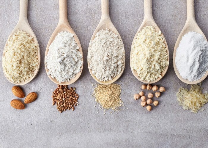 five types of gluten free flours on wooden spoons