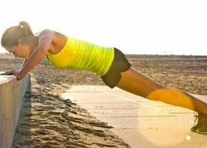 woman doing elevated push ups outdoors by the beach