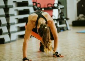 woman doing a hiit workout on a wood floor