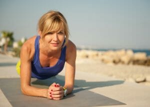 woman doing HIIT plank exercise by the beach