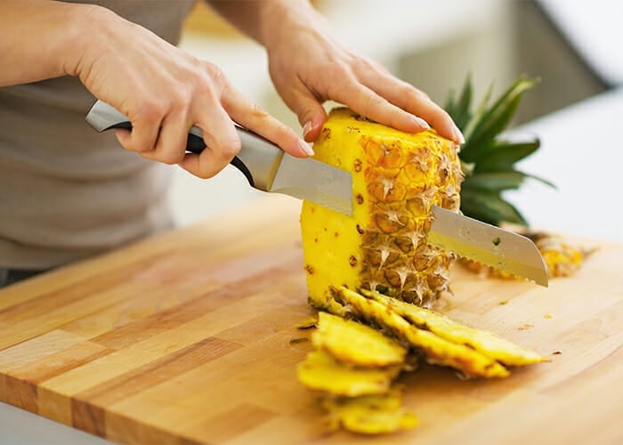 woman-cutting-pineapple