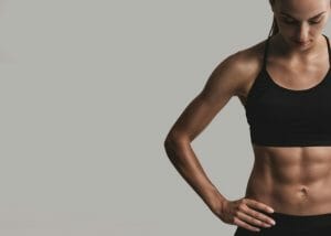 woman with six pack abs in a black sports bra