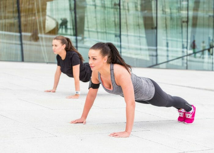 two women doing LIIT plank exercises next to each other