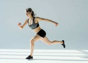 woman doing leg exercises in a white room