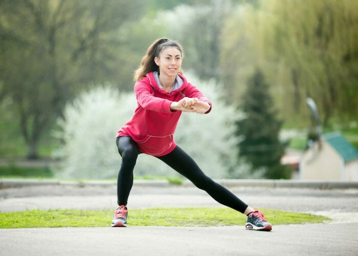 woman doing side lunges for leg exercise in an outdoor park