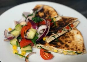 homemade quesadillas filled with vegetables on a white plate