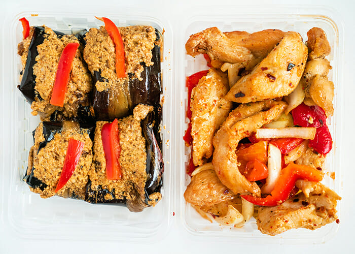 Two containers filled with Paleo meals from delivery services