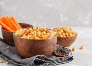 Bowls of hummus and carrot sticks