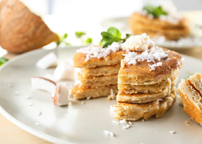 Stack of homemade paleo pancakes topped with coconut