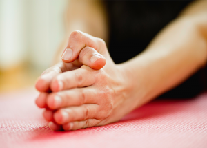 Close up of a woman's hands during a hot yoga class