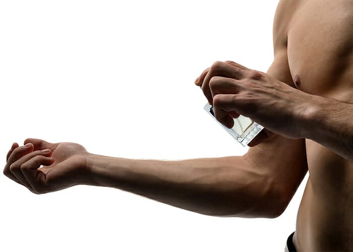 Man spraying DIY essential oil cologne blend on his arm