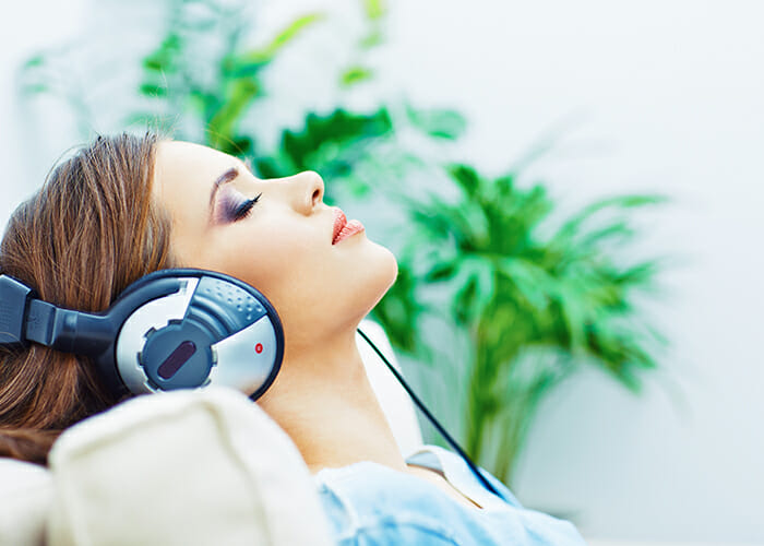 woman with eyes closed listening to music