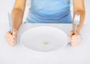 Woman eating Keto pills on a plate