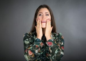 Woman with her hands on her face doing face yoga method exercises