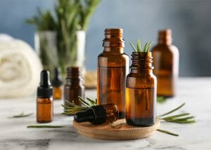 An assortment of amber bottles filled with rosemary essential oils with sprigs of rosemary