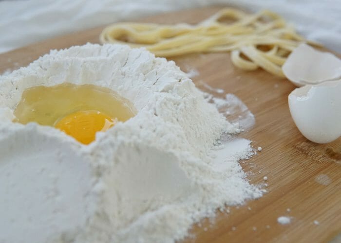 pile of cassava flour with an egg cracked in the middle