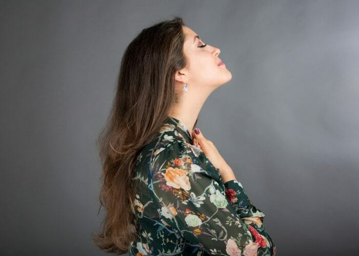 Woman stretching her neck by tilting her head up doing in the middle of a face yoga practice