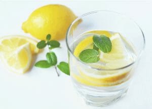 a glass of lemon water with lemon slices